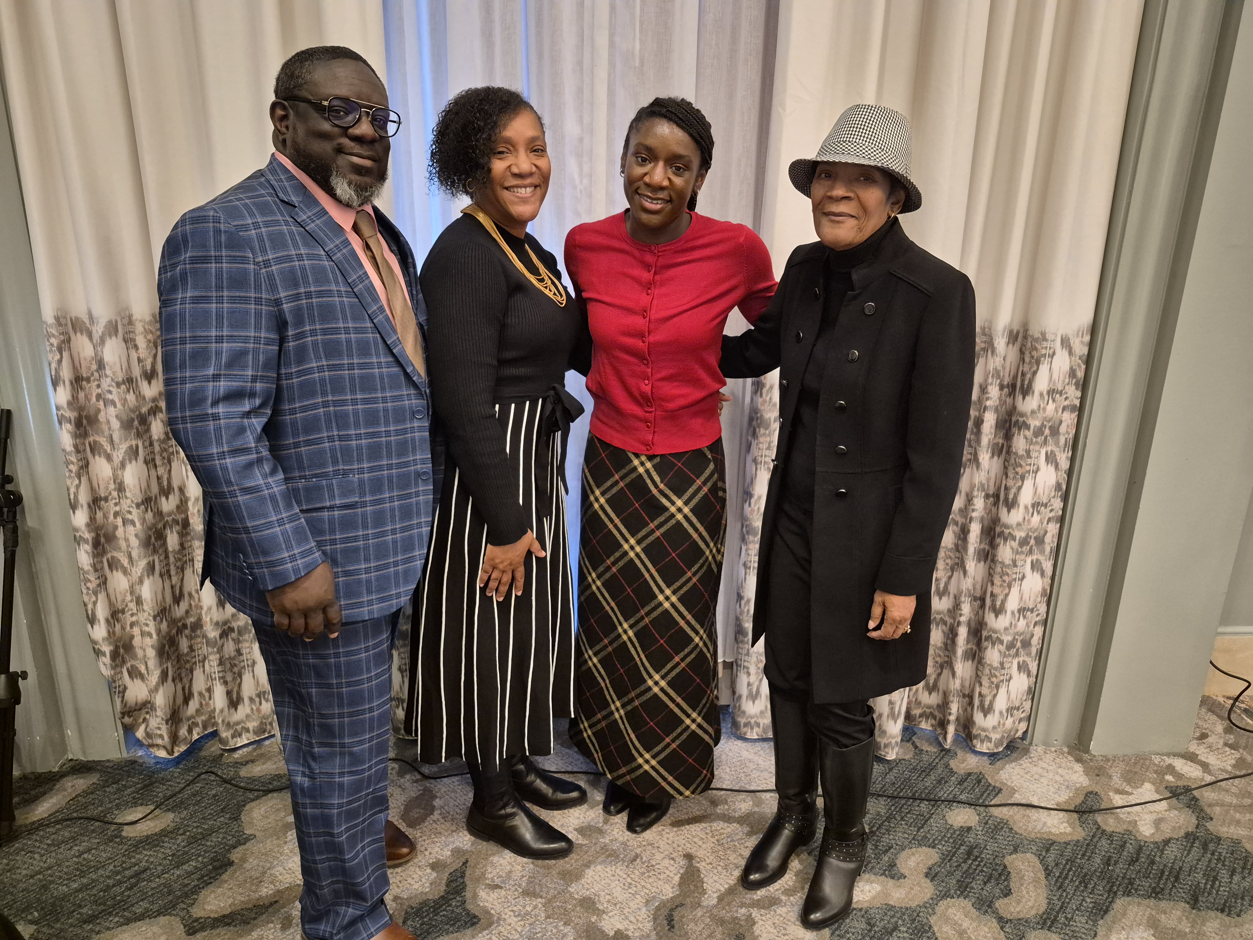 National Freedom Day Luncheon — group portrait of four adults posing together indoors.
